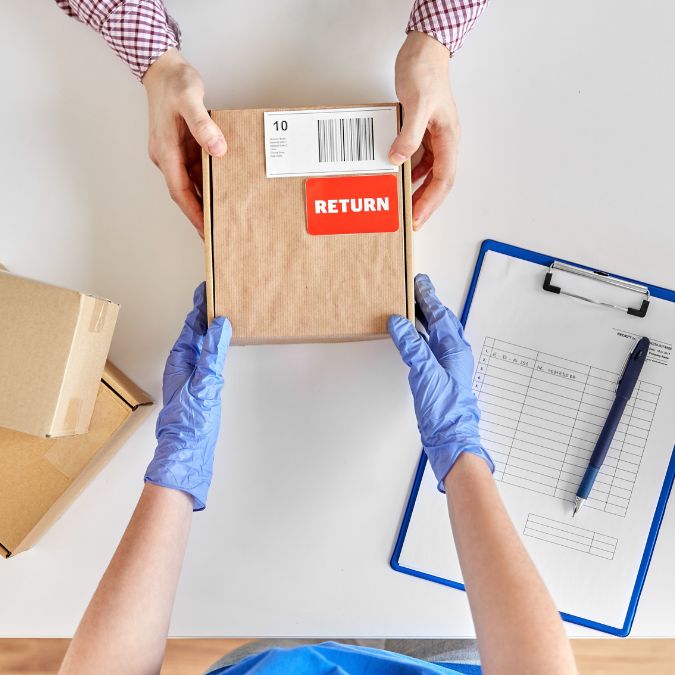 package for postal delivery being passed from one set of hands to another gloved set of hands