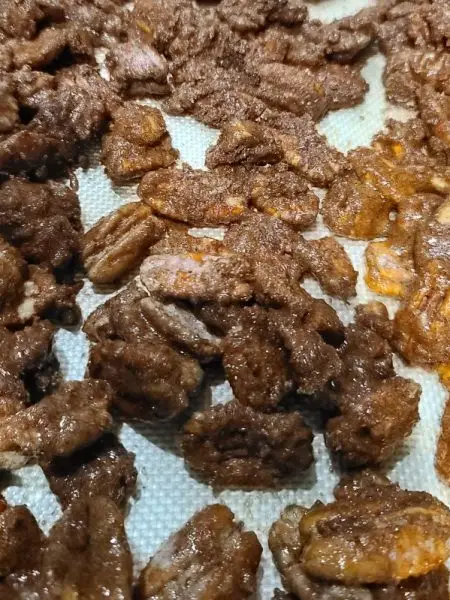 close up of candied pecans on silicone baking mat